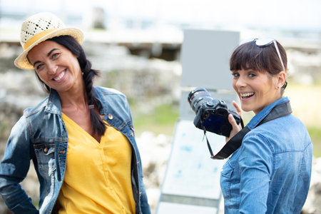 two women on holiday taking photographsの写真素材