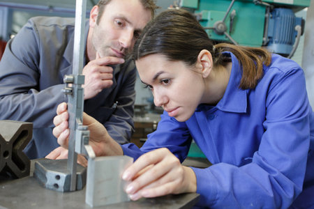 engineer showing equipment to a female apprenticeの写真素材