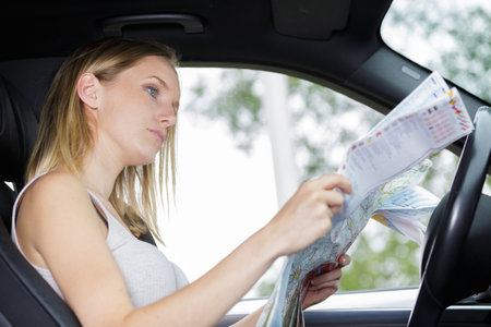 female driver parked up to study mapの写真素材