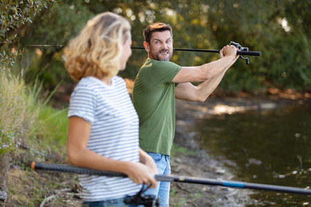 young couple is enjoying fishing on sunny dayの写真素材