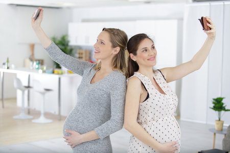 pregnant women taking selfie with mobileの写真素材