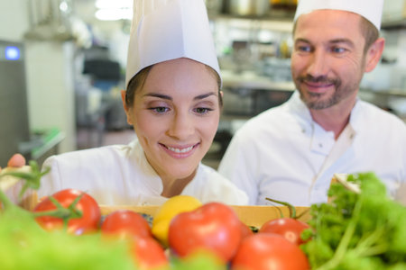 woman chef looking at tomatoesの写真素材
