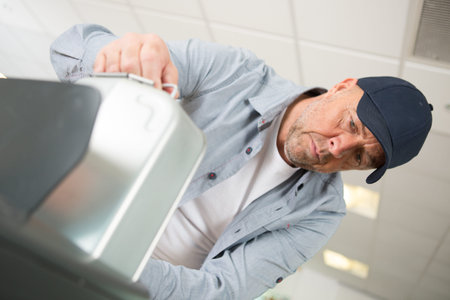 man working with an oil tank