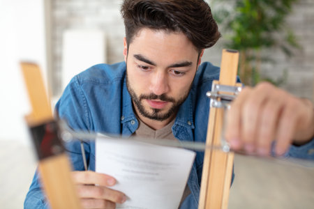 man tries himself to fold his furniture reads the instructionsの写真素材