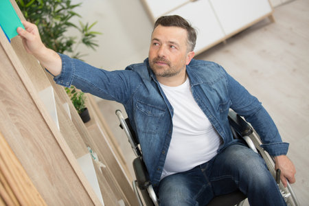 a man on wheelchair during everyday taskの写真素材