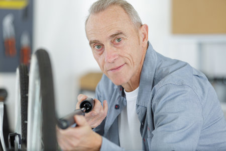 senior man pumping a bicycle tireの写真素材