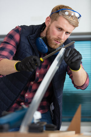 young carpenter focused while workingの写真素材