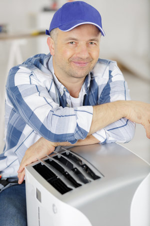 male technician repairing air conditionerの写真素材