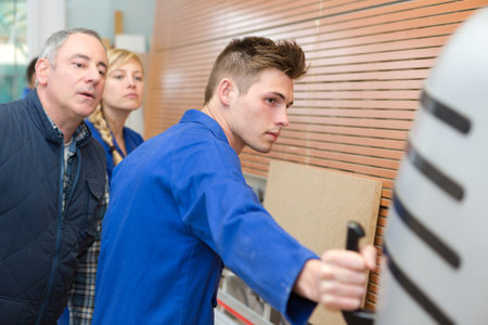 carpentry apprentice demonstrating machine operation