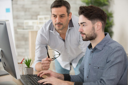 two businessmen working on a computerの写真素材