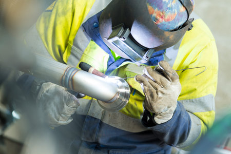 welding man welding pipe in industry