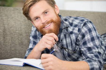 guy with a notebook sitting on the couchの写真素材