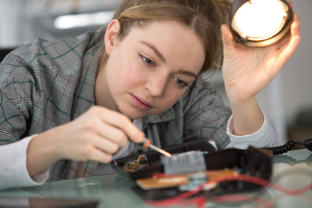 young woman repairing electronic boardの写真素材