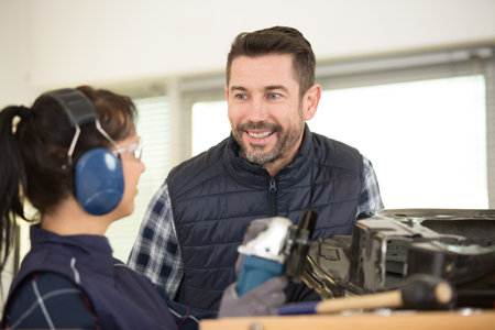 young male and female technicians in metalworks factoryの写真素材