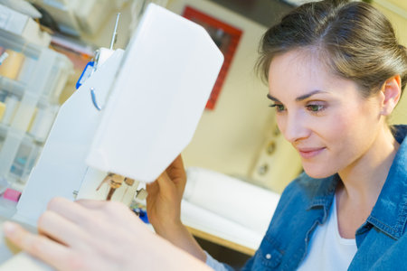 young woman sewing with sewing machineの写真素材