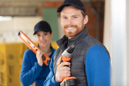 happy female builder and male colleague