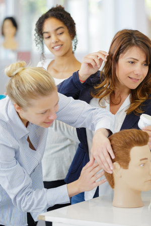 hairdresser training on male mannequinの写真素材
