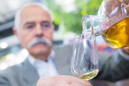 senior man with glass of cognacの写真素材