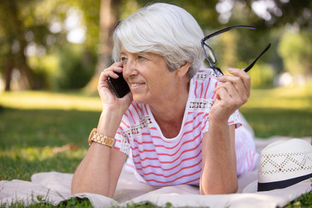 senior woman in fitness outfit relaxing in parkの写真素材