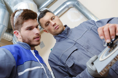 skilled worker giving instructions to an apprentice in a factory