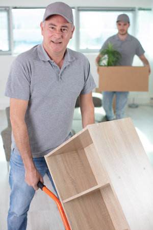 delivery man moving item on trolleyの写真素材