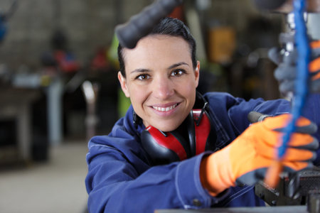 happy female metalworker in factory