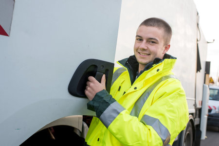 garbage collector smiling next to the truck