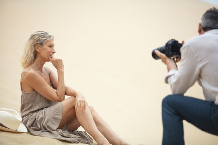 smiling mature woman posing in dunes during photoshootの写真素材