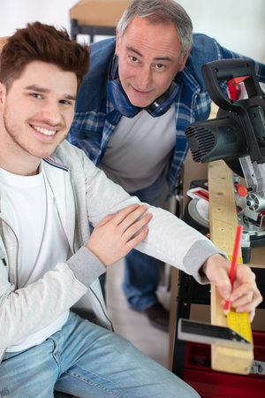 carpenter and apprentice inspecting the measurements
