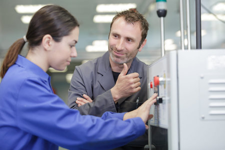a machine operator taking with factory supervisor