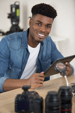 man cleaning lens of his digital camera with special brush