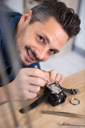 happy man fixing watch partsの写真素材