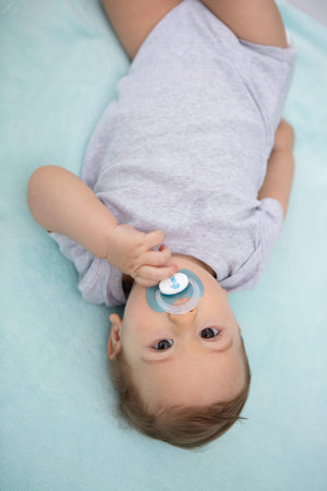 pretty baby is lying on the carpet