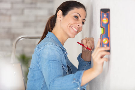 closeup of a blond young woman using spirit level