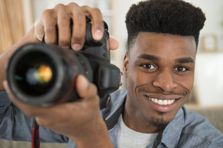 portrait of male photographer holding digital cameraの写真素材