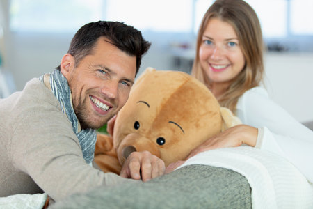 young couple sat with giant teddy bearの写真素材