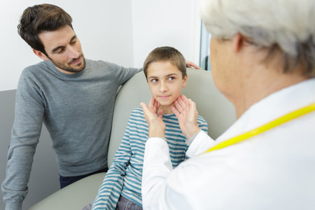 woman doctor examining little boy office
