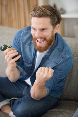 happy man concentrated playing video games with video game controller