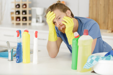 unmotivated man surrounded by household cleaning productsの写真素材