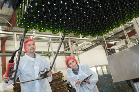 two serious workers doing their job on factory production line