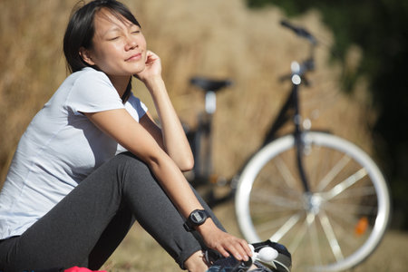 relaxing woman cyclist enjoys the sunの写真素材