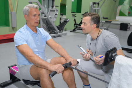 elderly man pulling some muscle strength in the gym