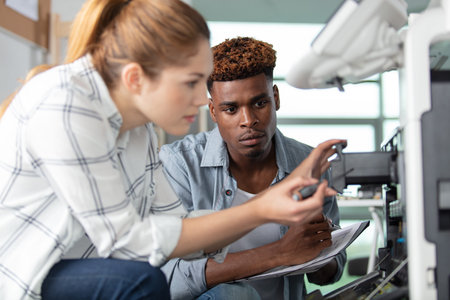 two young technicians repairing printer