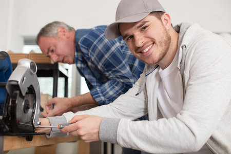 young man repairing a circular sawの写真素材