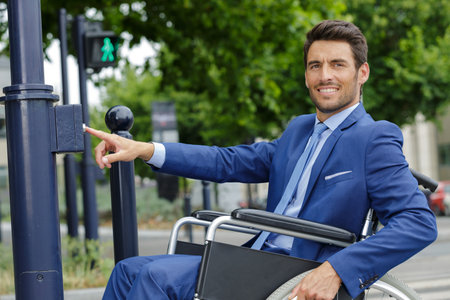 man in a wheelchair crossing roadの写真素材