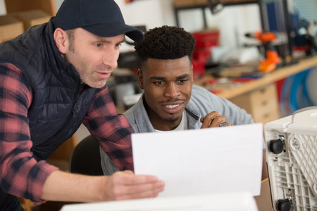 man and apprentice checking the paperwork