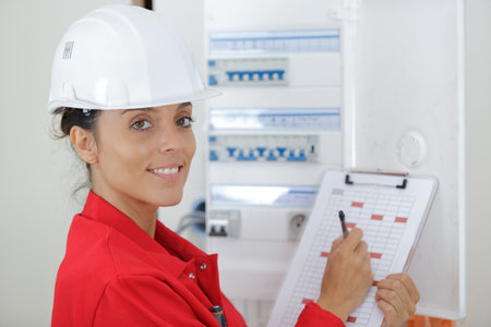 woman with clipboard inspecting electrical boxの写真素材