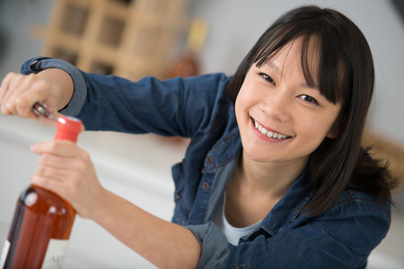 asian woman open bottle of wine