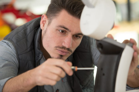 serious man repairing broken coffee machine