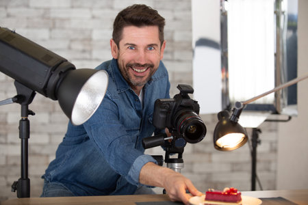 man with camera taking photos of fresh homemade pastriesの写真素材